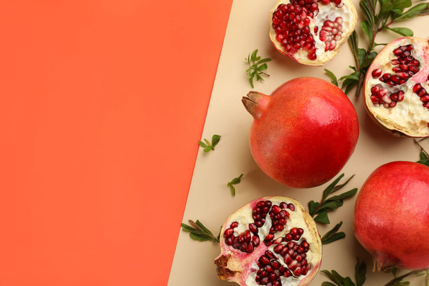 Flat lay composition with ripe pomegranates on color background. Space for text - Foto, imagen