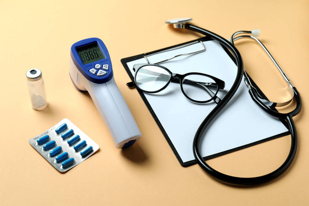 Lääketieteelliset työkalut ja kuumemittari ase beige tausta - Valokuva, kuva