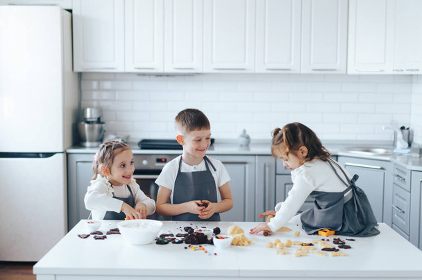 Çocuklar hamurdan kurabiye yapar. Çocuk konseptiyle boş zaman aktivitesi - Fotoğraf, Görsel
