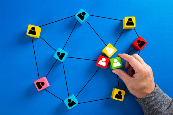 Drewniany sześcian blok drukuj ikonę osoby ekranu, które łączą sieć połączeń dla struktury organizacyjnej sieci społecznej i koncepcji pracy zespołowej. - Zdjęcie, obraz