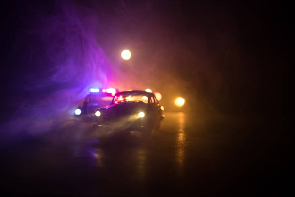 Rendőrautó üldöz egy kocsit éjszaka, ködös háttérrel. 911 Vészhelyzeti rendőrautó száguld a tetthelyre. Szelektív fókusz - Fotó, kép