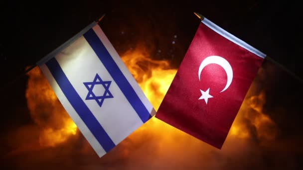 Israel ja Turkki pieniä lippuja palava tumma tausta. Käsitys sodan kriisistä ja valtioiden välisistä poliittisista konflikteista. Valikoiva painopiste - Materiaali, video