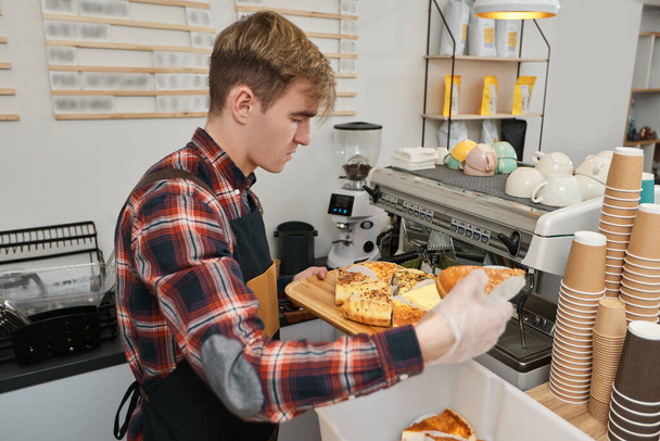 happy male worker in apron sells fresh bakery products - Fotografie, Obrázek