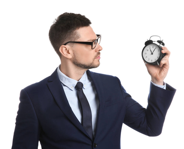 Businessman holding alarm clock on white background. Time management - Fotoğraf, Görsel