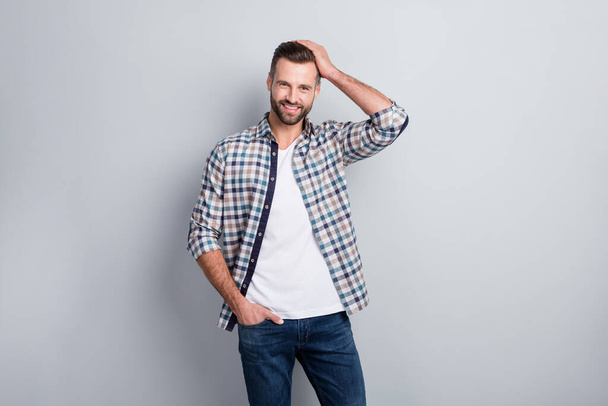 Photo portrait of cheerful smiling man in checkered shirt touching hairstyle isolated on grey color background - Fotó, kép