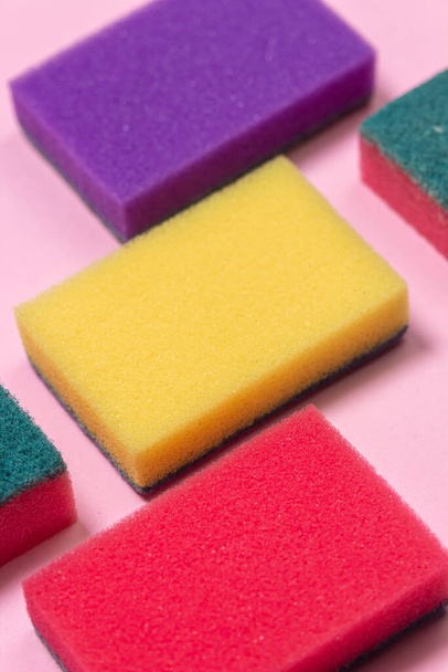 Lavar las esponjas sobre un fondo rosa. Esponjas de limpieza sobre un fondo de color. Herramientas de lavado y limpieza en interiores. - Foto, Imagen