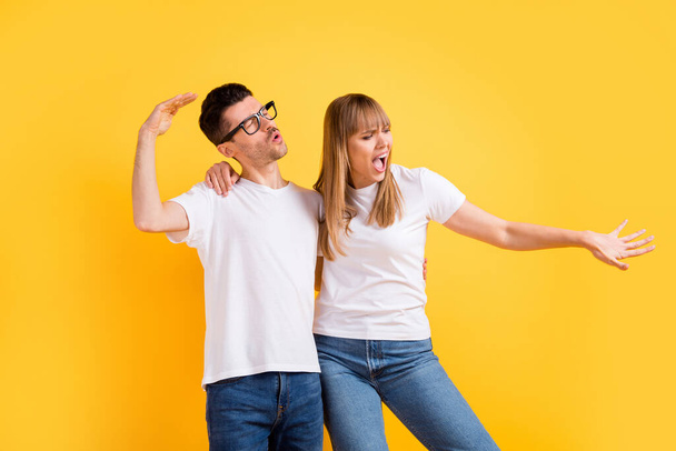 Photo of charming pretty two persons dressed white t-shirt glasses dancing isolated yellow color background - Foto, imagen