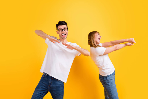 Photo of cute adorable young couple wear white t-shirt spectacles dancing isolated yellow color background - Fotó, kép