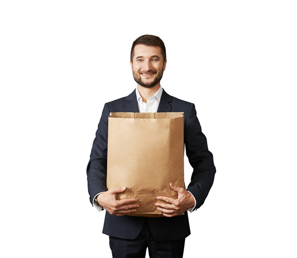 man holding paper bag and smiling - 写真・画像