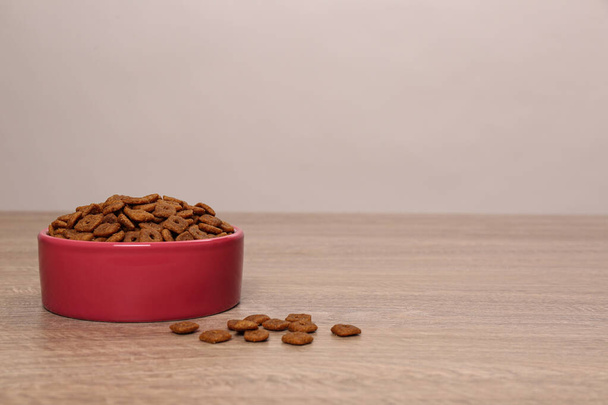 Dry food in pet bowl on wooden surface, space for text - Foto, Bild