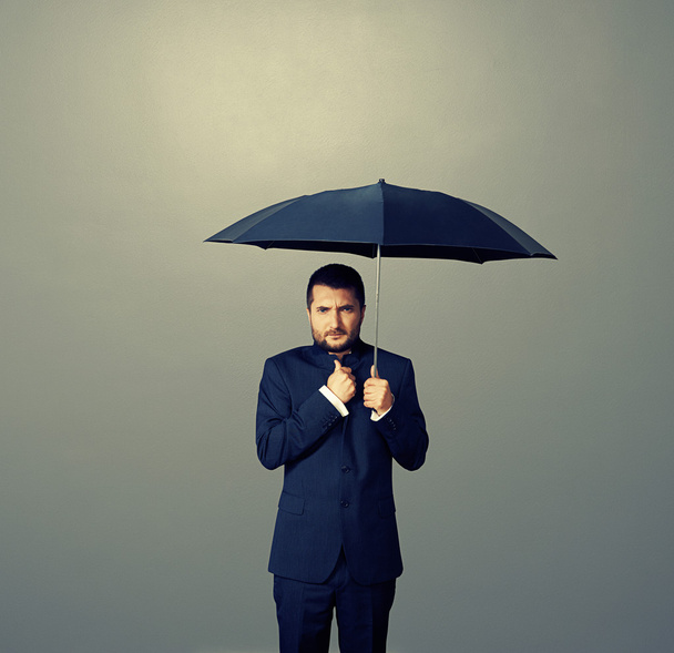 człowiek pod czarny parasol na ciemnym - Zdjęcie, obraz