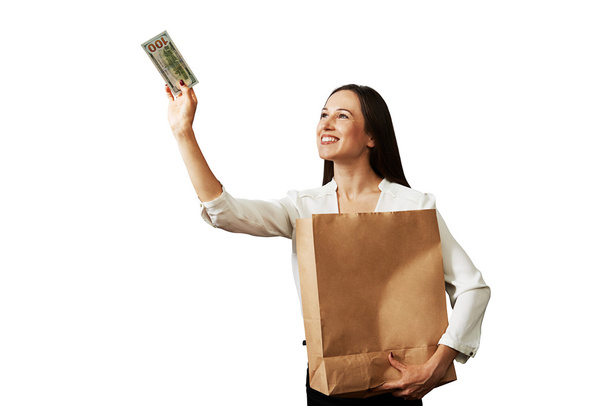 žena držící papírový pytlík a bankovek - Φωτογραφία, εικόνα
