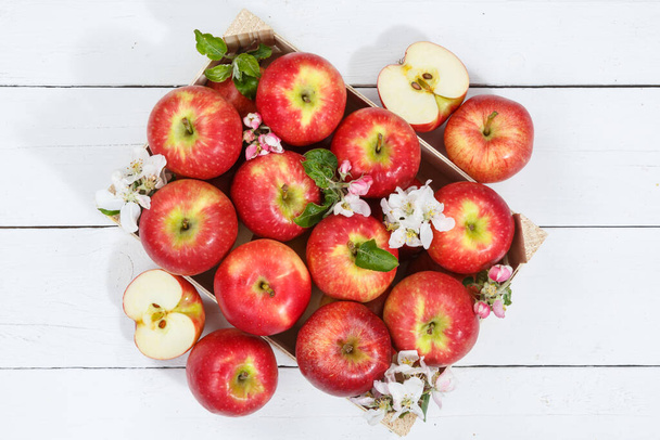 Apples fruits red apple fruit box on wooden board with leaves and blossoms food - Фото, изображение
