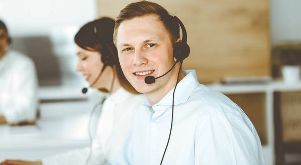 Group of diverse operators at work in call center. Businessman sitting n headset at customer service office. Business concept - Foto, immagini