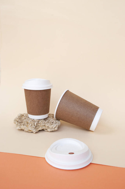 Двухградируемые бумажные коричневые кофейные чашки с биоразлагаемыми белыми крышками. - Фото, изображение