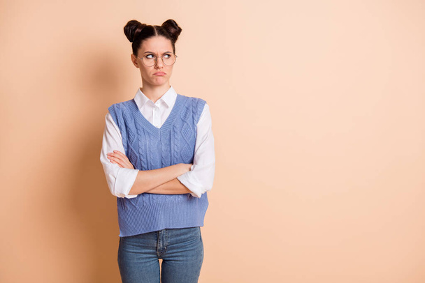 Photo of unsure upset girl dressed knitted waistcoat glasses arms crossed looking empty space isolated beige color background - Foto, immagini