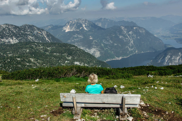 Solo kız dağ manzarasını ve Alp Gölü 'nü seyrediyor. Sırt çantalı, zirvede dinleniyor. Aktif tatil özgürlüğü kavramı. Seyahat sahnesi. - Fotoğraf, Görsel