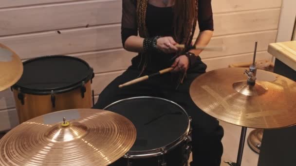 Střední část zpomalení nepoznatelné ženské bubeník na sobě dlouhé dredy a rock-styl oblečení hrát na bicí v garáži staré školy proměnil v hudební studio - Záběry, video