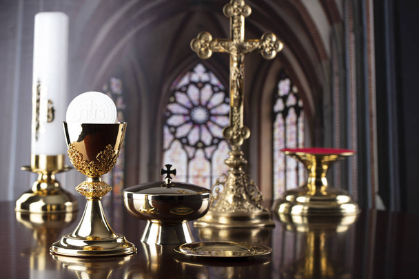Première Communion. Thème religion catholique. Crucifix, le calice de Croass et d'or et galette sur l'autel. - Photo, image