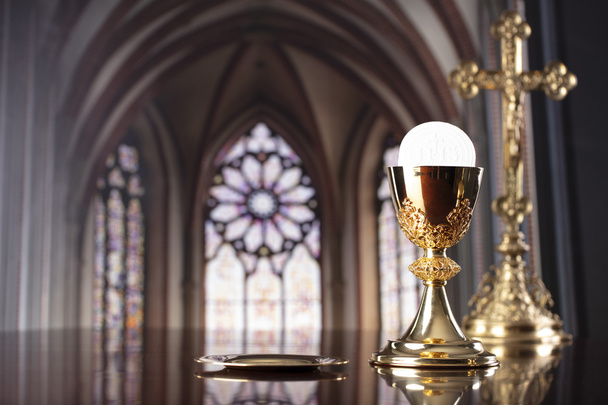Eerste Heilige Communie. Katholieke religie thema. Kruisbeeld, de gouden kelk en de gouden kelk op het altaar. - Foto, afbeelding