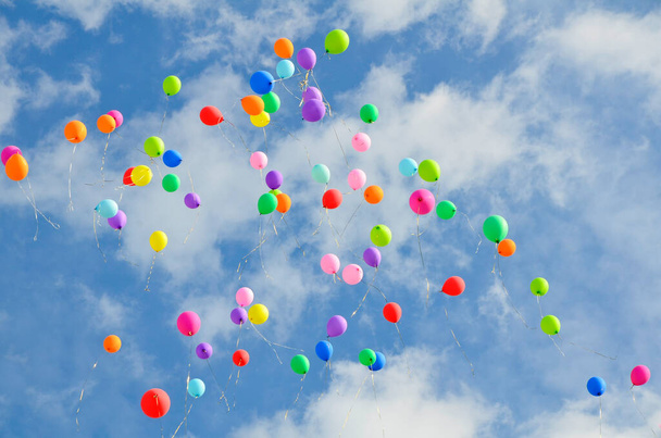 Spousta barevných balónů letících proti modré obloze s mraky s kopírovacím prostorem. Koncept dovolené, Den dětí, Poslední výzva ve škole a školce, narozeniny. - Fotografie, Obrázek