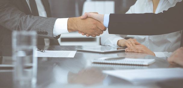 Handshake as successful negotiation ending, close-up. Unknown business people shaking hands after contract signing in modern office - Foto, Imagen