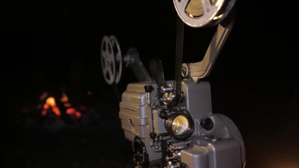 Een retro bioscoop projector werkt op straat. Draaispoelen van film. - Video