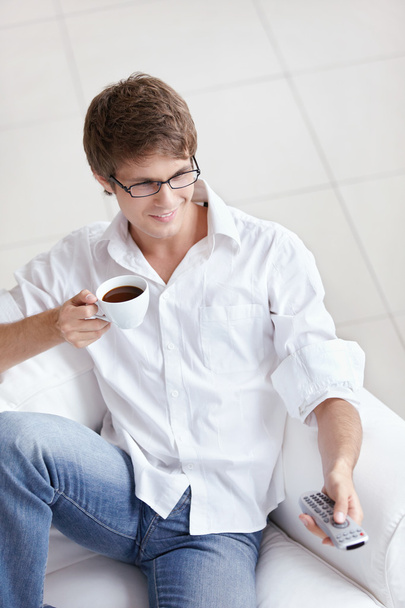 ein Mann mit einer Tasse Kaffee Schalter TV-Kanäle - Foto, Bild