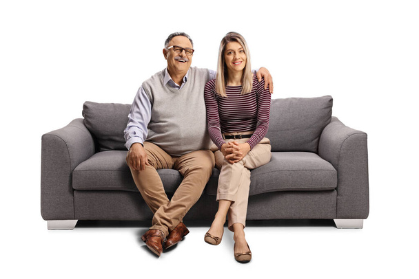 Ojciec i córka siedzący na kanapie w objęciach odizolowani na białym tle - Zdjęcie, obraz