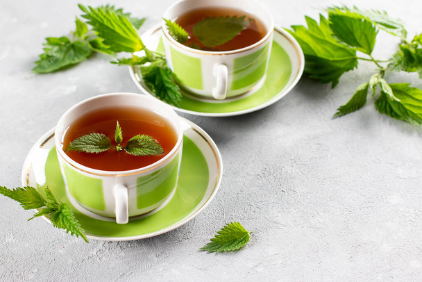Nettle tea két csészével, friss csípős csalán gyógynövények. Népi orvosság. A vitaminok forrása. Fénymásolási hely - Fotó, kép