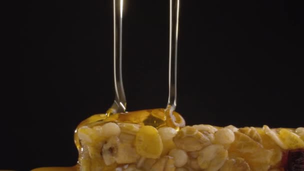 Miel vertiendo en una barra de cereales - Imágenes, Vídeo