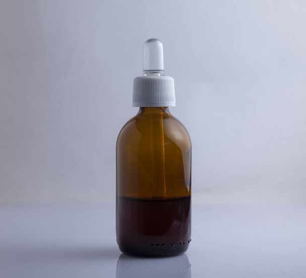 Amber vape vloeibare fles met schaduw geïsoleerd op lichte achtergrond - Foto, afbeelding