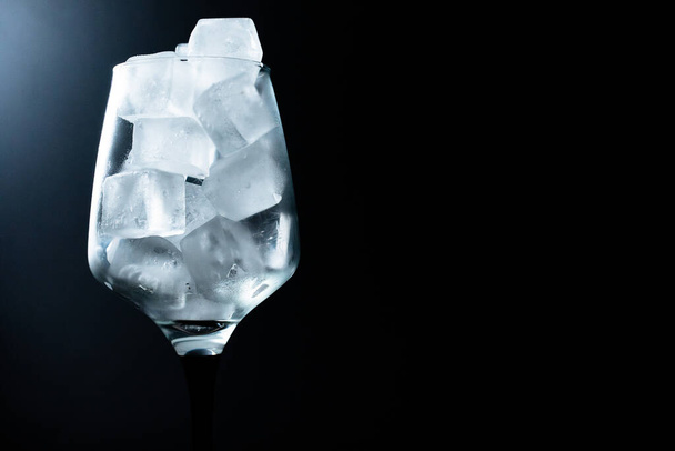 Одиночное стекло со льдом на черном фоне - Фото, изображение