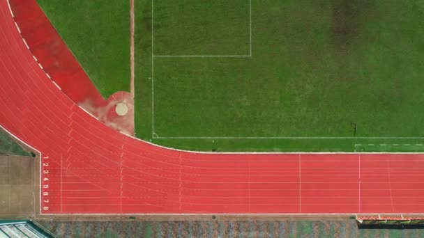 Versenypálya vagy atlétikai pálya rajtvonala sávszámokkal a stadionban Top view Drone shot high angle view - Felvétel, videó