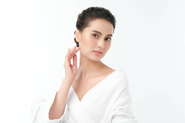 Gyönyörű fiatal ázsiai nő visel fürdőköpeny fehér háttér, Arcápolás, Arckezelés, Kozmetológia, szépség és spa koncepció. - Fotó, kép