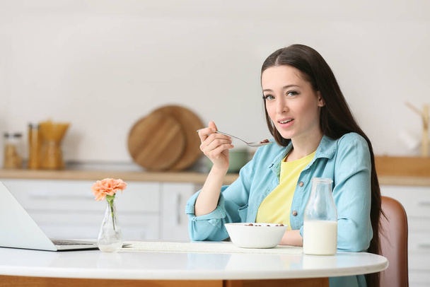 Молодая женщина завтракает дома - Фото, изображение