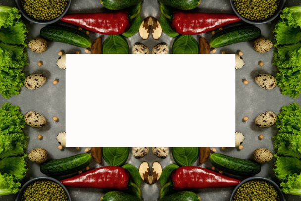 Copie el espacio en un rectángulo blanco sobre un fondo de verduras frescas. Composición vegetal de calabacín, garbanzos, lentejas y huevos de codorniz - Foto, imagen