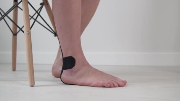 Μια γυναίκα κάνει μια άσκηση για να αναπτύξει ένα πόδι, κοντινό πλάνο του ποδιού - Πλάνα, βίντεο