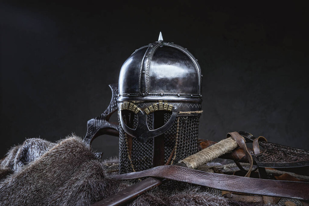 Studio shot of knight helmet around axe and fur - Photo, image