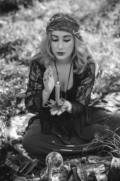 Alma gitana... Mujer boho con cartas del Tarot, velas y bola mágica en el campo, estilo de vida, predicción, ideas para el disfraz en Halloween - Foto, Imagen