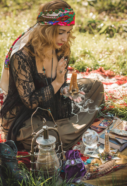 Alma gitana... Mujer boho con cartas del Tarot, velas y bola mágica en el campo, estilo de vida, predicción, ideas para el disfraz en Halloween - Foto, Imagen