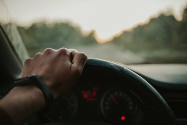 A closeup shot of a man holding the steering wheel while driving - Valokuva, kuva