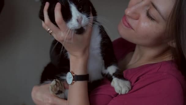 Liebenswerte Frau mit Sommersprossen spielt mit Katze, die sie hält und umarmt - Filmmaterial, Video
