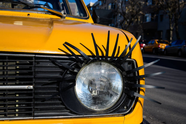 Details of an light from an old yellow car decorated on street in Bucharest, Romania - Photo, Image