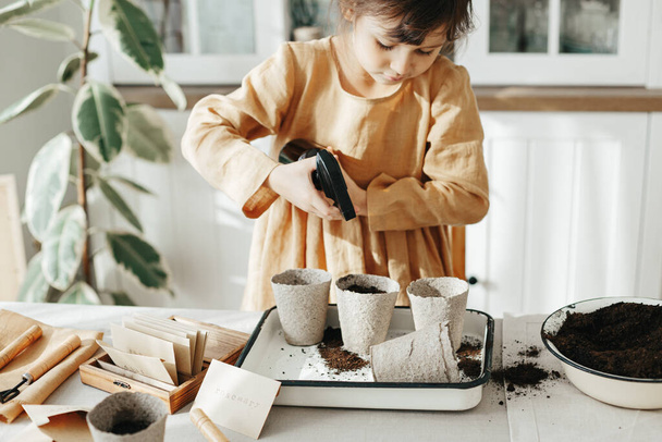 6 years old girl planting herbs at home - Foto, Imagen