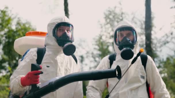 Epidemiologen in Ausrüstung posieren gegen verschwommenen Park - Filmmaterial, Video