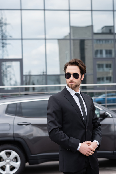 bearded safeguard in suit and sunglasses near car  - Photo, Image