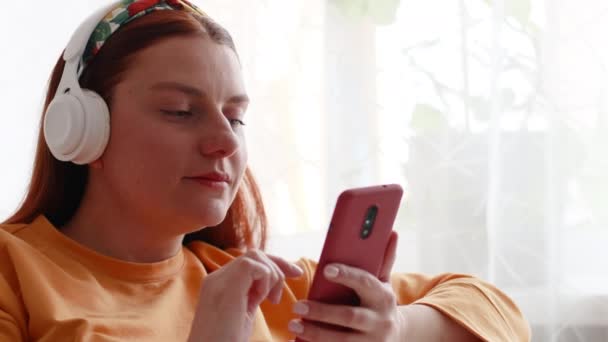 Imagen de cerca de una hermosa mujer joven sosteniendo y utilizando el teléfono móvil - Metraje, vídeo