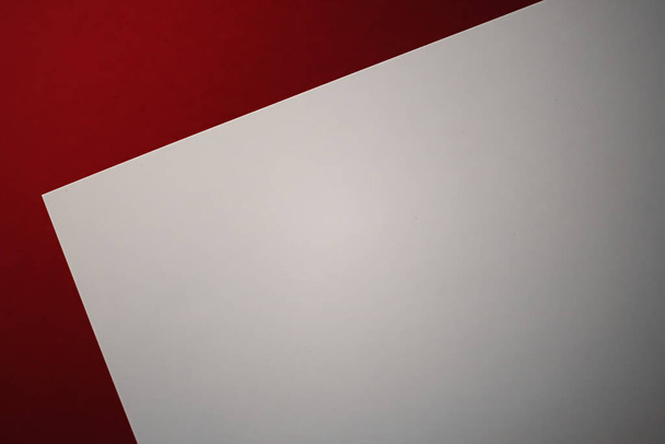 Boş A4 kağıt, kırmızı zemin üzerine beyaz ofis kırtasiyesi düz kaplama, lüks markalaştırma yatağı ve model kimlik tasarımı - Fotoğraf, Görsel