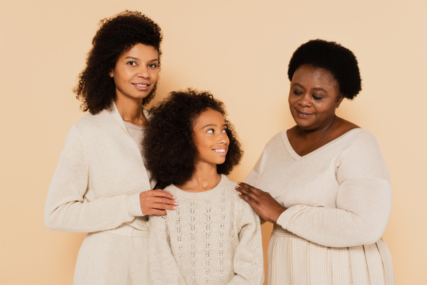 african american mother and grandmother standing with smiling granddaughter isolated on beige - Fotografie, Obrázek